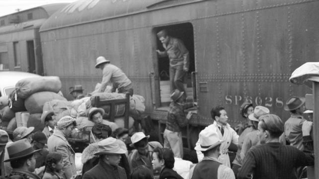 Japanese Americans boarding a train bound for one of ten American concentration camps.