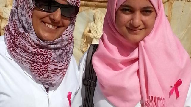 Two medical students are promoting breast cancer awareness by wearing pink ribbons 