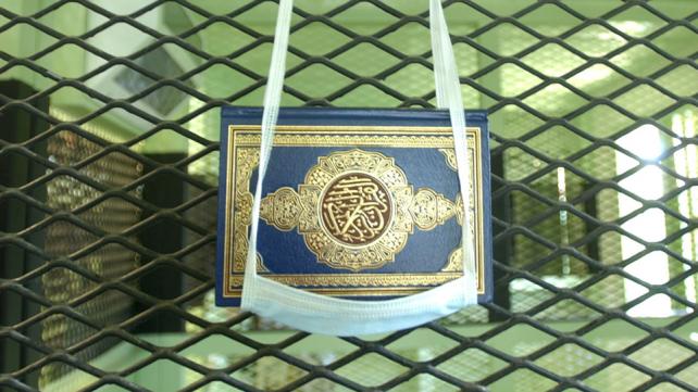 A Koran hung in a surgical mask, in Guantanama