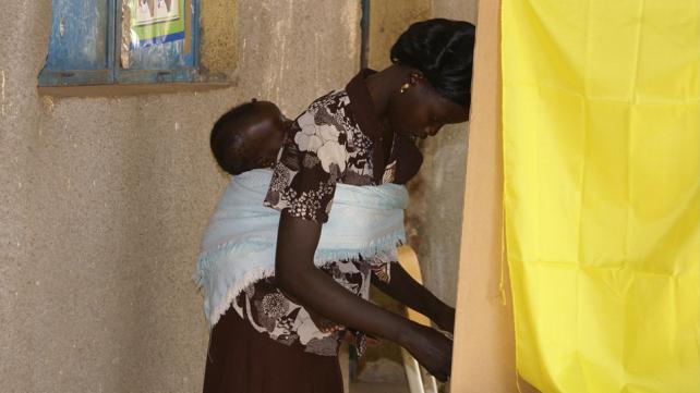 Woman with baby in a voting booth