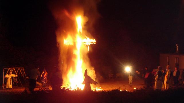 Ku Klux Klansmen and women at a cross lighting in on November 12th, 2005
