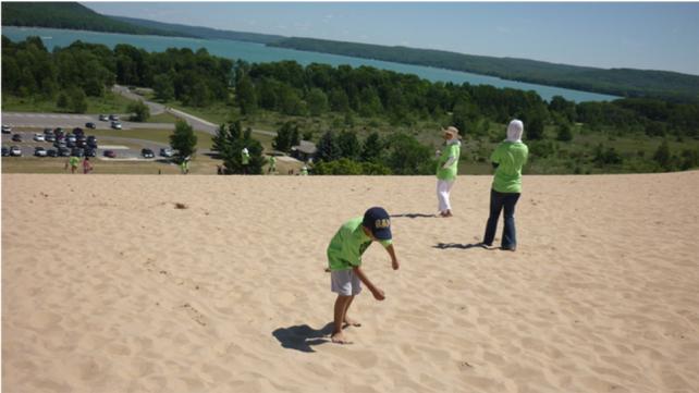kids playing on a sand dune in summer