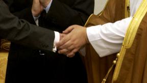 Muslim and person of other faith shake hands.  <a href =  “http://upload.wikimedia.org/wikipedia/commons/1/12/US_Navy_040628-F-0193C-008_Ambassador_L._Paul_Bremer_and_Iraqi_President_Sheikh_Ghazi_Ajil_al-Yawar_shake_hands.jpg”>Link to original photo</a>