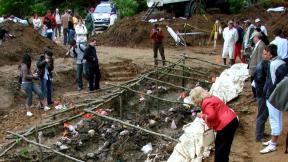Delegates of the International Association of Genocide Scholars (IAGS) examine an exhumed mass grave of victims of the July 1995 Srebrenica massacre